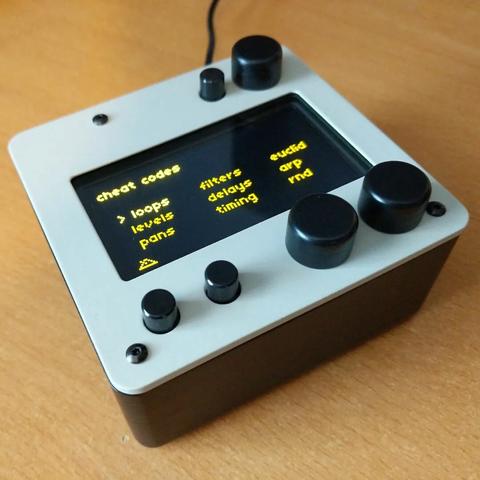 A small box with knobs and a screen. The bottom half and knobs are black; the top is a pale grey. The finish is smooth.